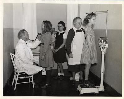 Doctor examining children at school, 1941