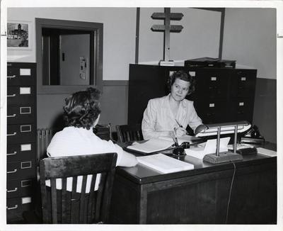 Nurse receiving patient at clinic, 1958